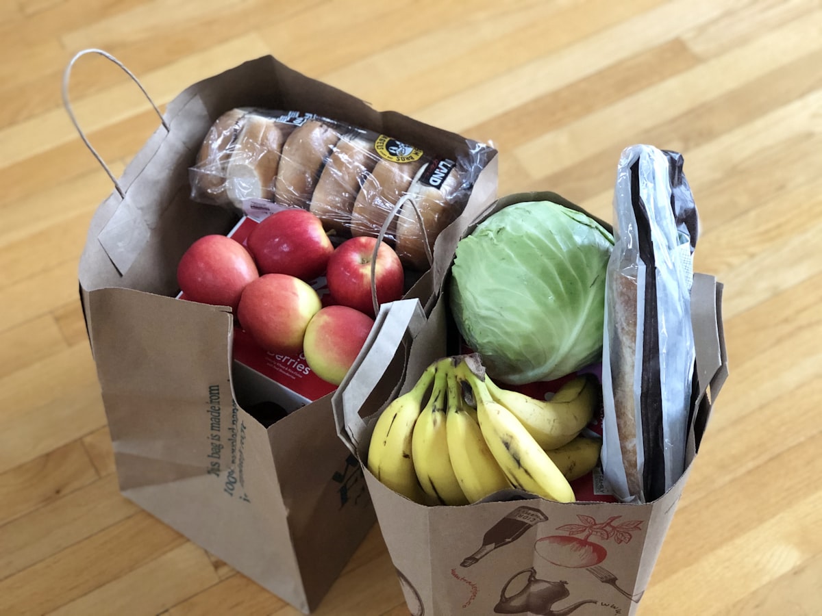Compras de mercado com pães artesanais, frutas frescas e lanches prontos para piqueniques e lanches de viagem